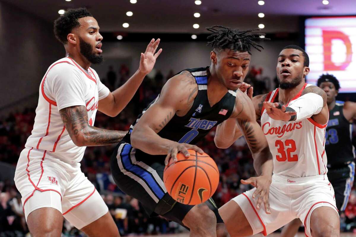Memphis guard Earl Timberlake (0) drives between Houston guard Kyler Edwards, left, and Reggie Chaney (32) during the first half of an NCAA college basketball game Saturday, Feb. 12, 2022, in Houston. (AP Photo/Michael Wyke)