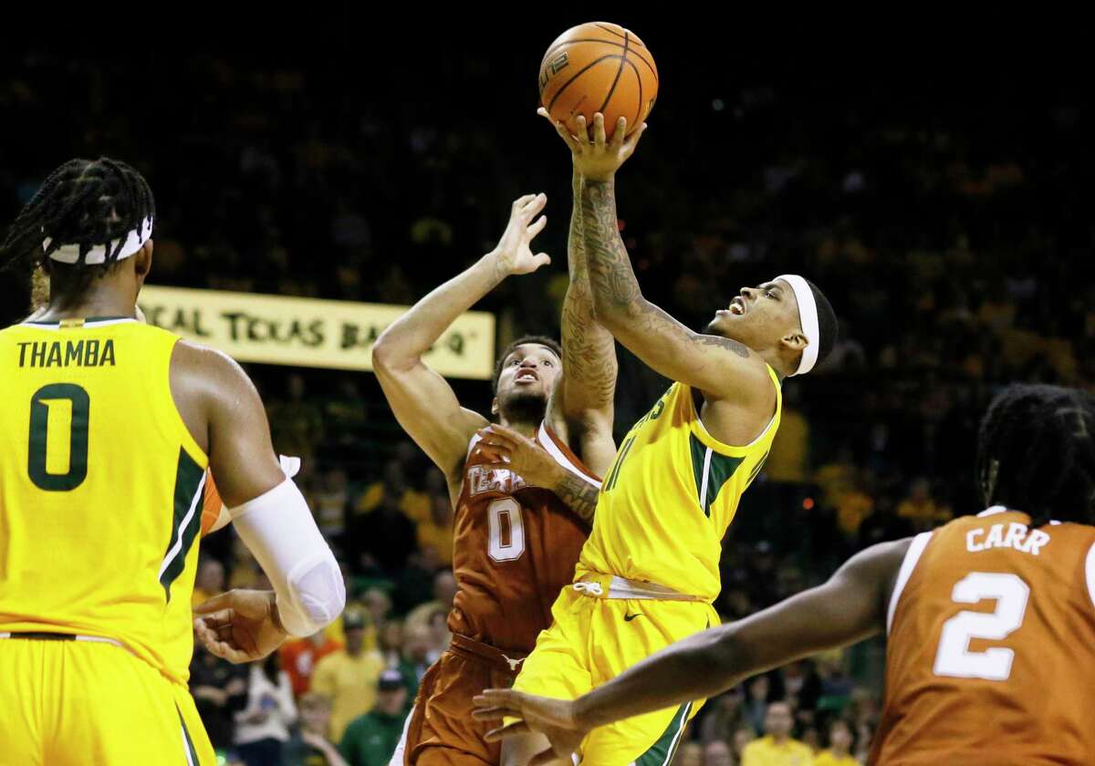 Baylor’s James Akinjo, right, shoots over Texas forward Timmy Allen (0) during Saturday’s game in Waco.