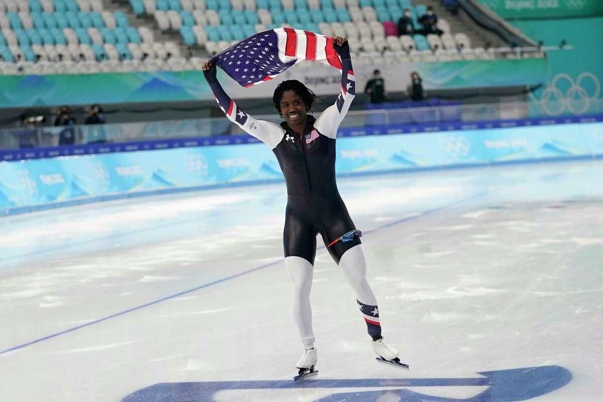 Erin Jackson of the United States holds up an American flag after winning the gold medal in the speedskating women's 500-meter race at the 2022 Winter Olympics, Sunday, Feb. 13, 2022, in Beijing. (AP Photo/Ashley Landis)