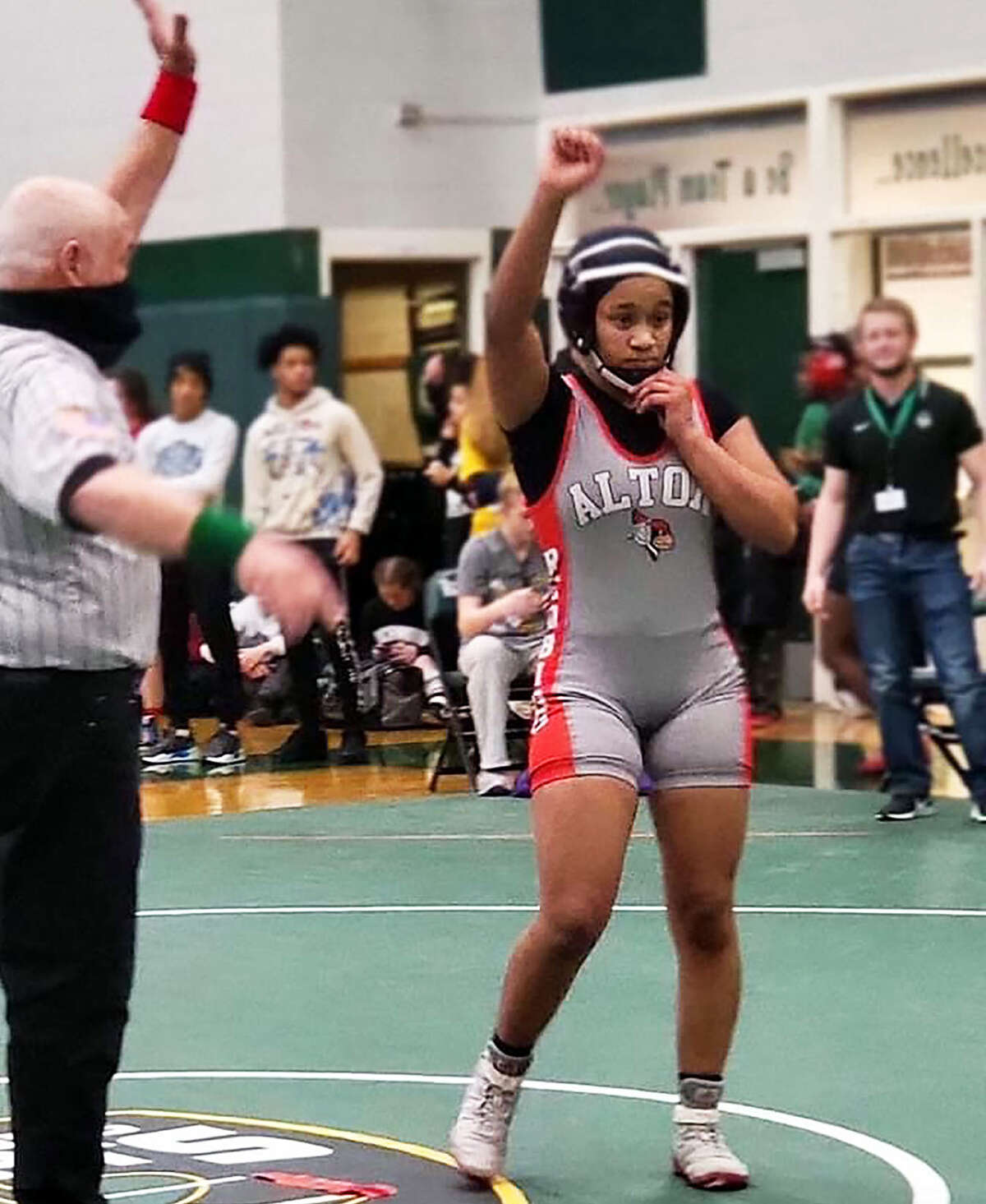 Alton's Antonia Phillips raises her fist after winning her school's first girls wrestling sectional title Saturday at the inaugural IHSA Girls Wrestling Sectional Tournament at Peoria Richwoods. Phillips defeated Savannah Hamilton of El Paso 6-0 in the championship bout at 140 pounds.