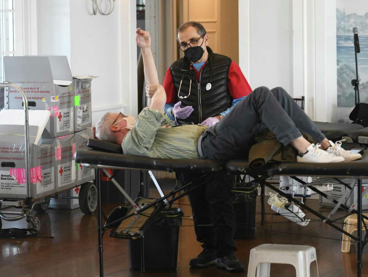 Collections technician Carl Muzio assists Darien's Chris Moran as he donates blood at the American Red Cross blood drive at the Belle Haven Club in Greenwich, Conn. Wednesday, Feb. 9, 2022. The Red Cross is experiencing the worst blood shortage in over a decade and donations are greatly needed. The next blood drive will be Feb. 10 at Trinity Church in Cos Cob followed by another on Feb. 14 at Greenwich American Red Cross.