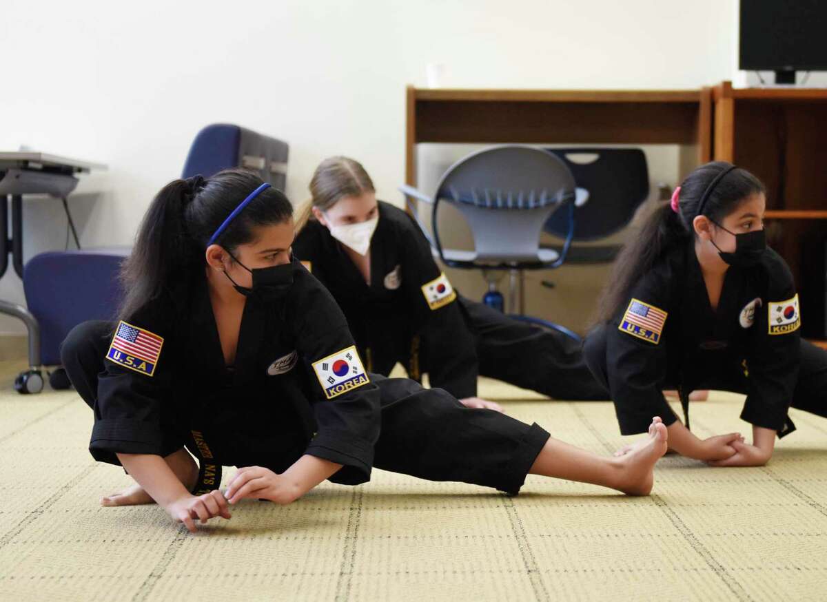 Traditional Tae Kwon Do performers Ritaj Saleh, left, 13, Clara Bonomo, center, 13, and Lujine Saleh, 10, stretch out before performing at the Lunar New Year celebration at the Ferguson Library in Stamford, Conn. Sunday, Feb. 13, 2022. Presented in partnership with Traditional Martial Arts and Club Kung Fu, the event celebrated the Year of the Tiger with activities including a Chinese acrobatic performance and Tae Kwon Do and Wing Tsun Martial Arts demonstrations.