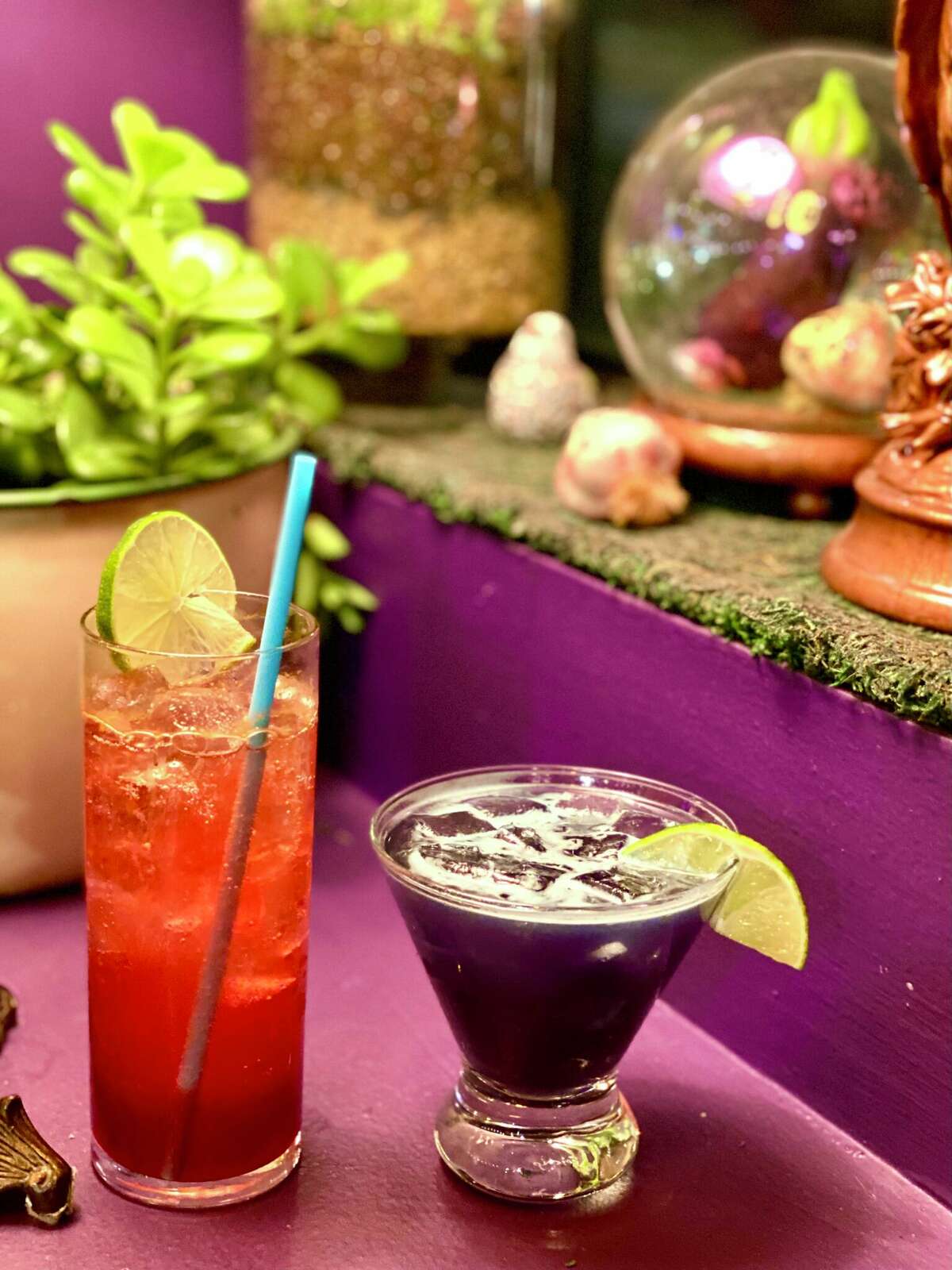 At left, the hibiscus-tinted Unbound cocktail from Wizard Burger. At the right, the restaurant's purple margarita.