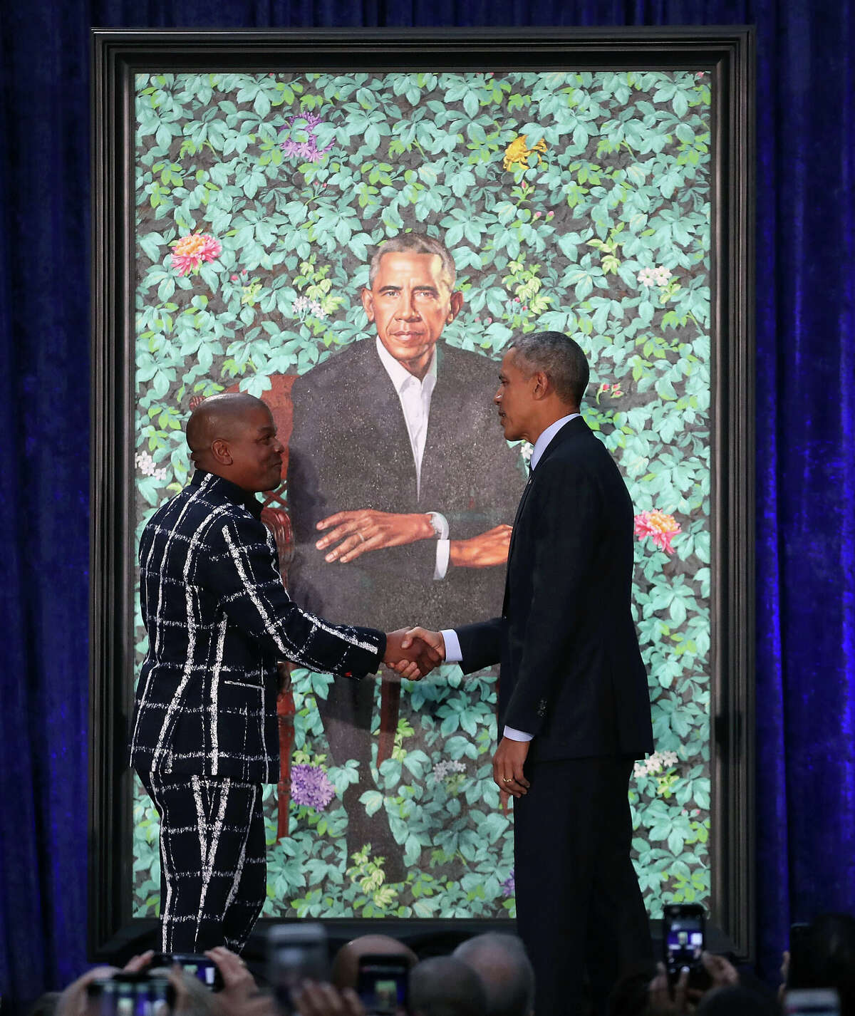Former U.S. President Barack Obama stands artist Kehinde Wiley next to his newly unveiled portrait during a ceremony at the Smithsonian's National Portrait Gallery, on February 12, 2018 in Washington, DC. The portraits were commissioned by the Gallery, for Kehinde Wiley to create President Obama's portrait, and Amy Sherald that of Michelle Obama. 