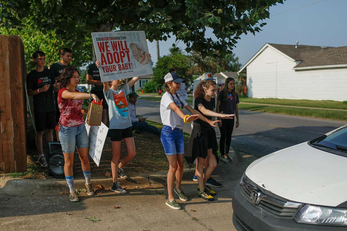 A group of protesters including Keziah Hoffman, 17 (left) and Riley Pritchard, 17 (second from left) attempt to stop a car that was entering the Trust Women’s clinic where abortions are performed on Friday, Aug. 6, 2021 in Oklahoma City, Oklahoma.