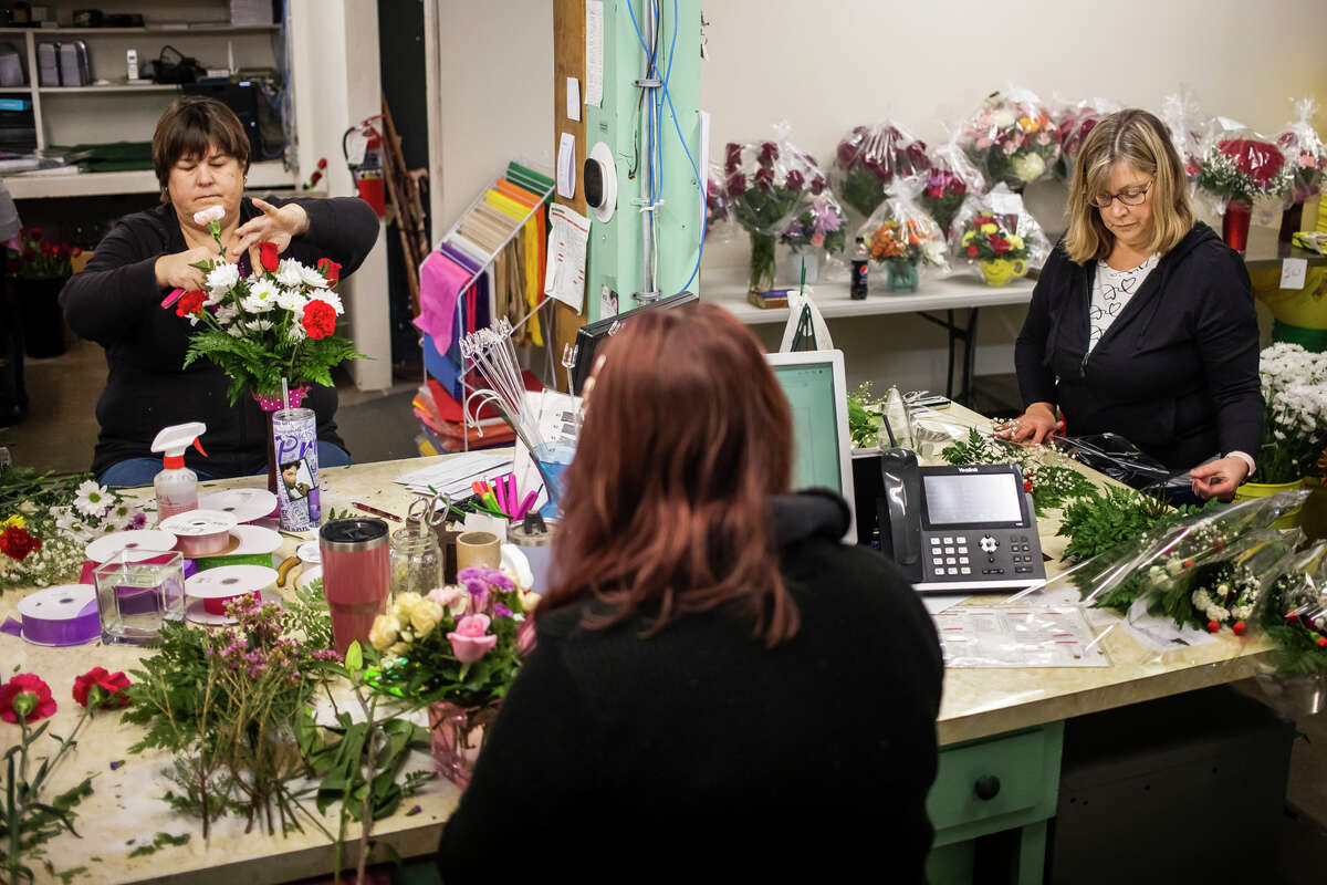 From left, Sara Pitch, Alisha Gwizdala and Maureen Kozuch prepare flower arrangements for Valentine's Day Monday, Feb. 14, 2022 at Village Green in Midland.