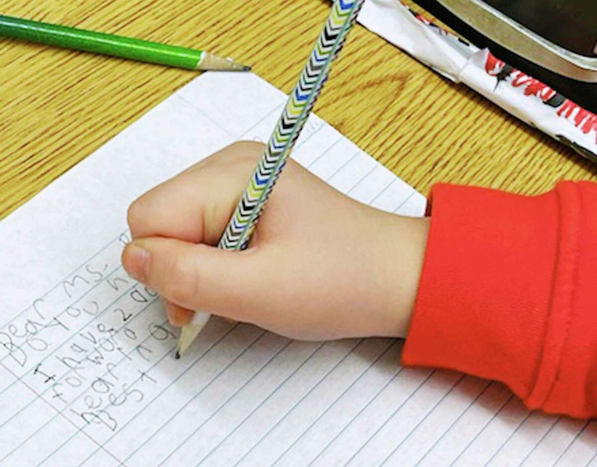 A third-grade student writes an essay.