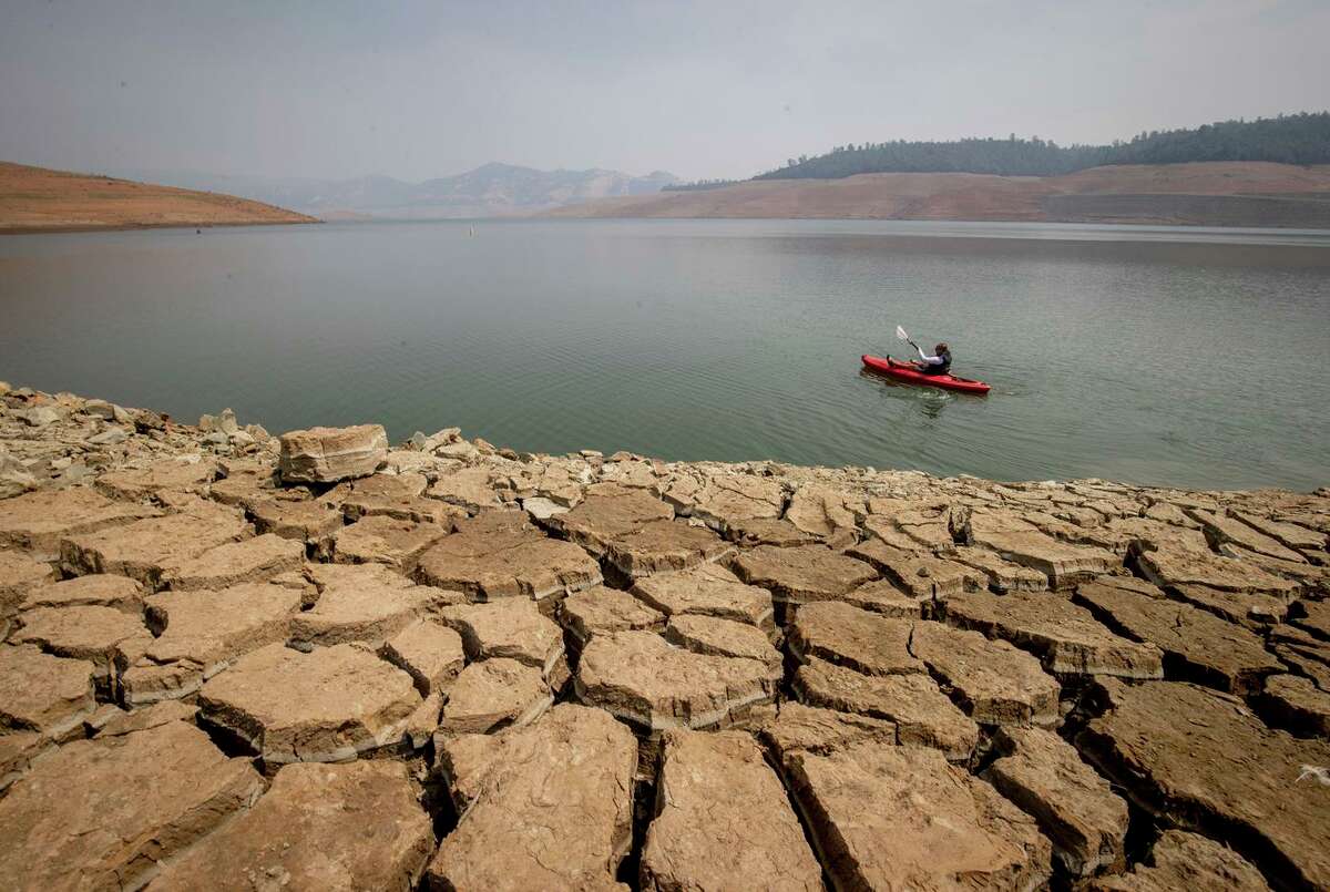 A kayaker paddles in Lake Oroville in August. Reservoir levels remain low in California because of continuing drought conditions. Researchers call the period since 2000 a megadrought.