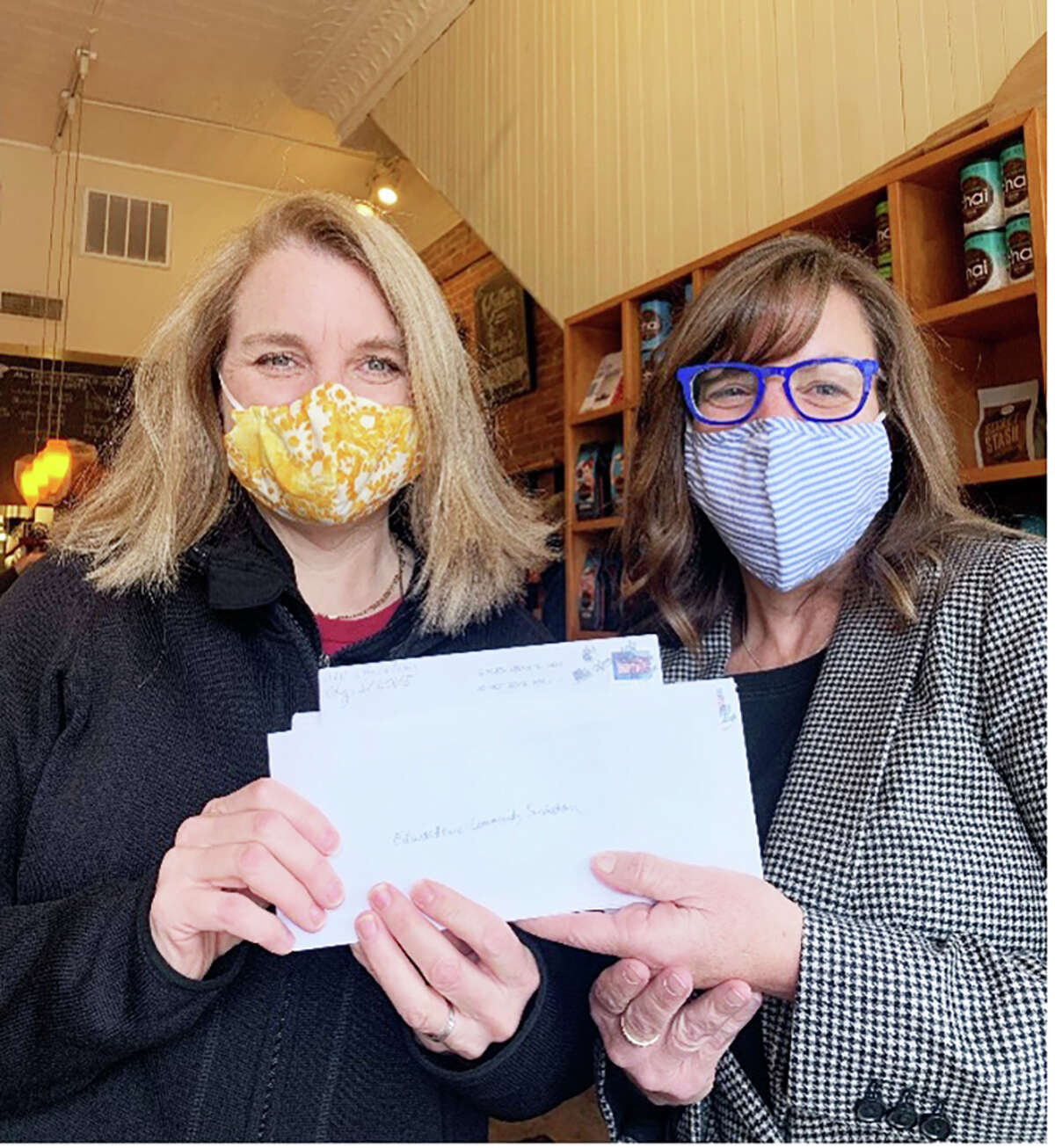 State Rep. Katie Stuart, D-Edwardsville, (right) presents a donation to Pam Farrar (left), executive director of the Edwardsville Community Foundation for tornado relief efforts at 222 Artisan Bakery on behalf of the Illinois House Moderate Caucus. On Monday, Stuart and other members of the House Labor and Commerce Committee virtually to discuss warehouse safety standards. 