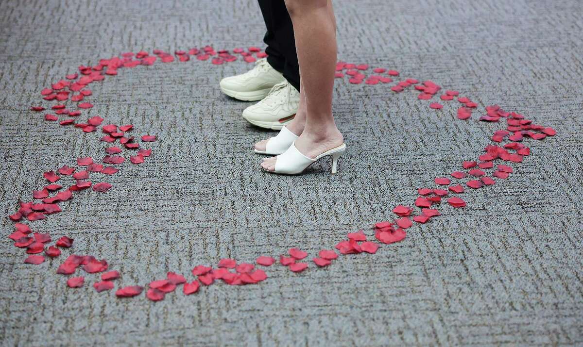 Hazel Duong and Kami Truong are surrounded by rose petals in the shape of a heart as the two get married in Judge Fredericka Phillips courtroom at the Harris County Civil Courthouse on Monday, Feb. 14, 2022 in Houston .