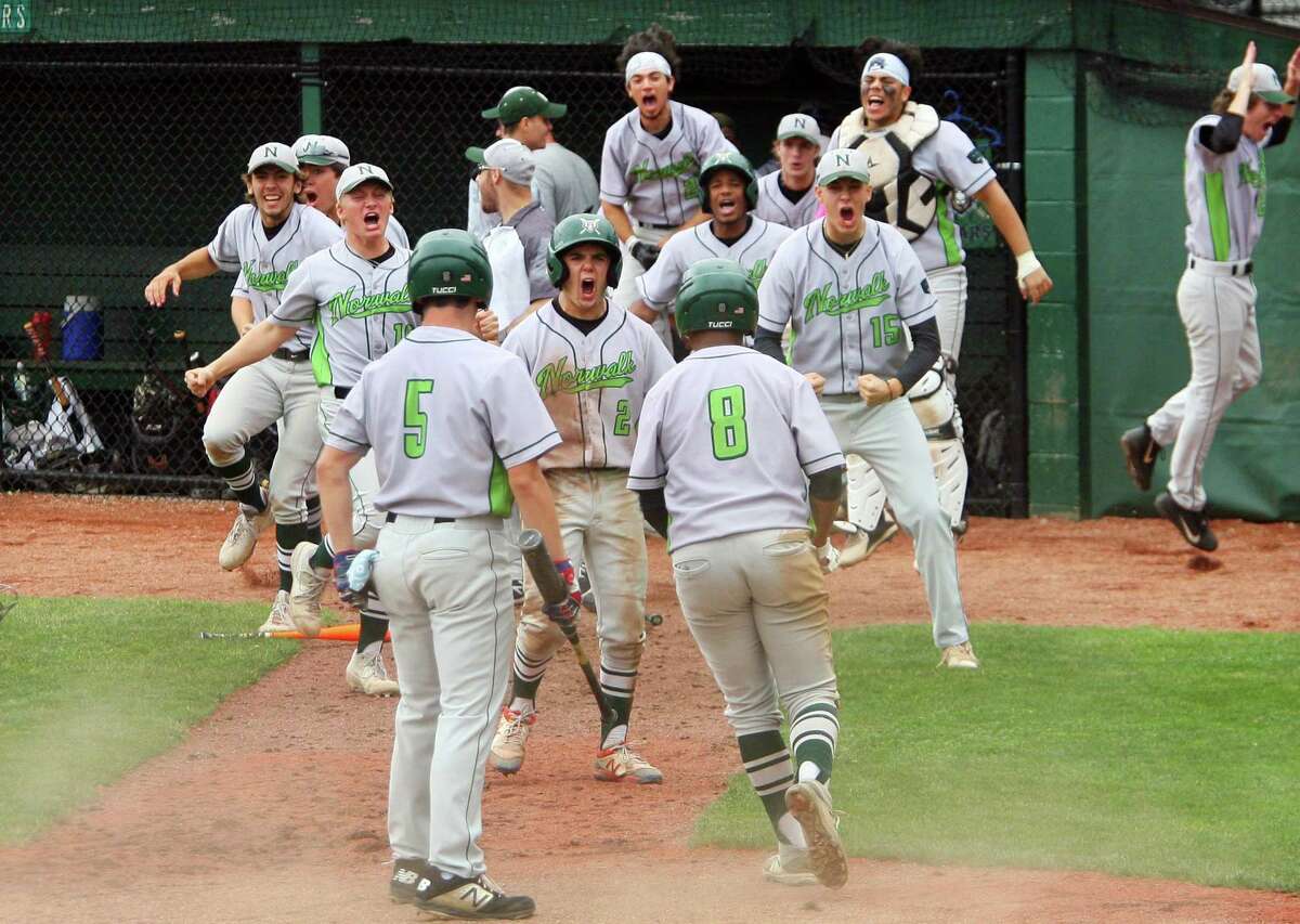 After a single by Norwalk's Konstantinos Kodonas (13), teammates rush to celebrate a run brought in by Noah Maldonado (8) during Class LL state championship baseball action against Westhill at Palmer Field in Middletown Conn., on Saturday June 12, 2021.