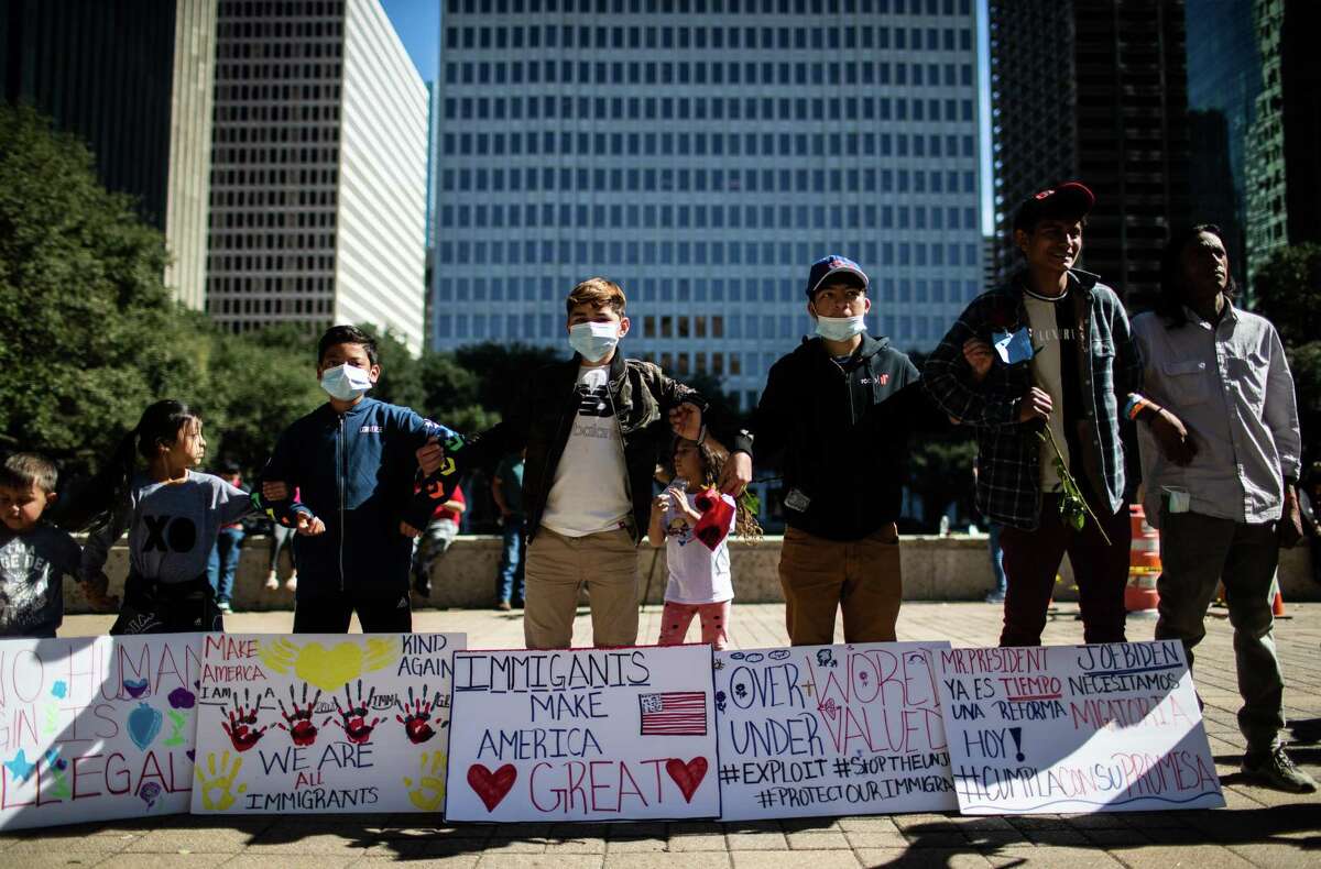 Children link arms in support of one another during the Day Without Immigrants rally in front of City Hall, on Monday, Feb. 14, 2022, in Houston.