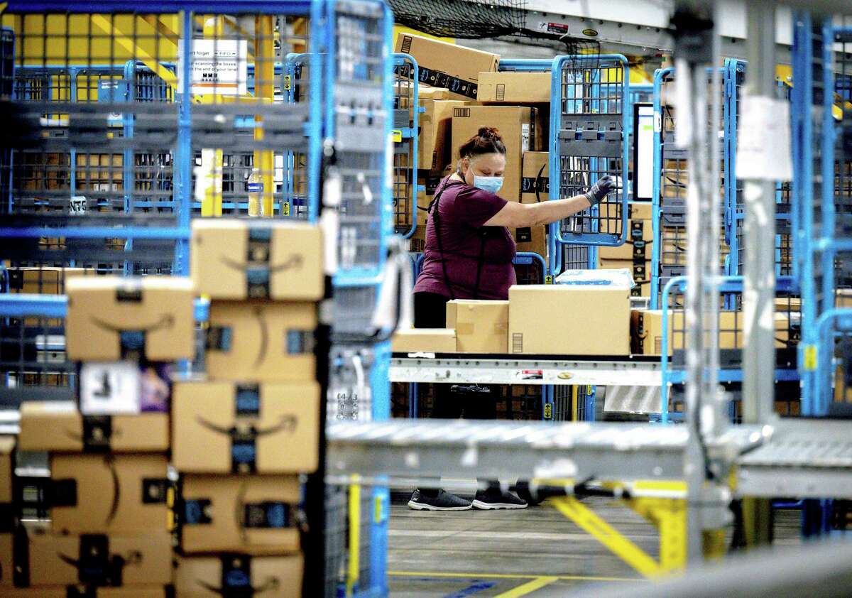 A worker sorts out packages in the outbound dock at Amazon fulfillment center in Eastvale, Calif., on Aug. 31, 2021.