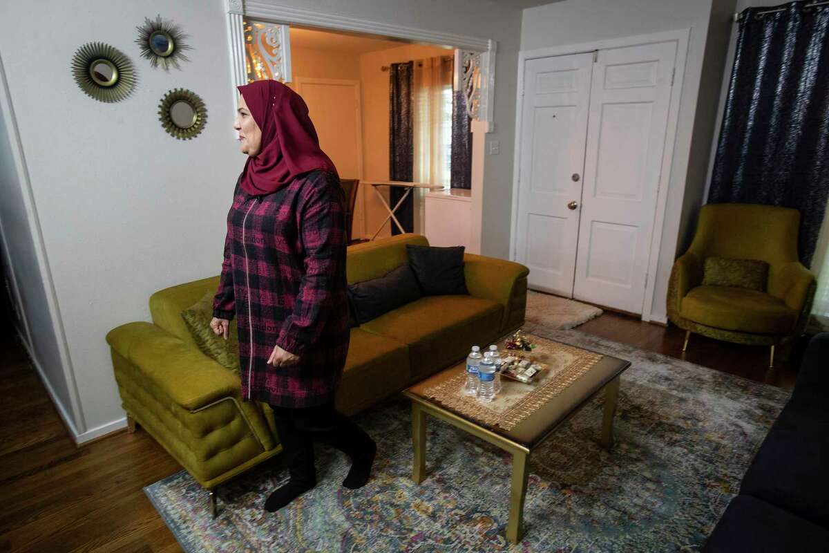 Rawaa Hussein, an Iraqi refugee living and working in Houston, walks through her living room Thursday, Feb. 3, 2022 in Houston. Lacking health literacy, insurance, and reliable transportation, the population requires extensive medical accomodations that can be hard to find. Many flock to places based on word of mouth, creating a bottleneck at clinics overwhelmed by periodic COVID waves.