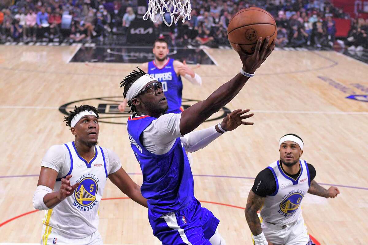 Los Angeles Clippers guard Reggie Jackson, center, shoots as Golden State Warriors center Kevon Looney, left, and guard Gary Payton II defend during the first half of an NBA basketball game Monday, Feb. 14, 2022, in Los Angeles. (AP Photo/Mark J. Terrill)