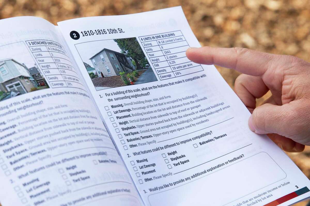 While on a walking tour in Berkeley, planning director Jordan Klein and City Council Member Terry Taplin refer to a booklet showing examples of different types of housing.