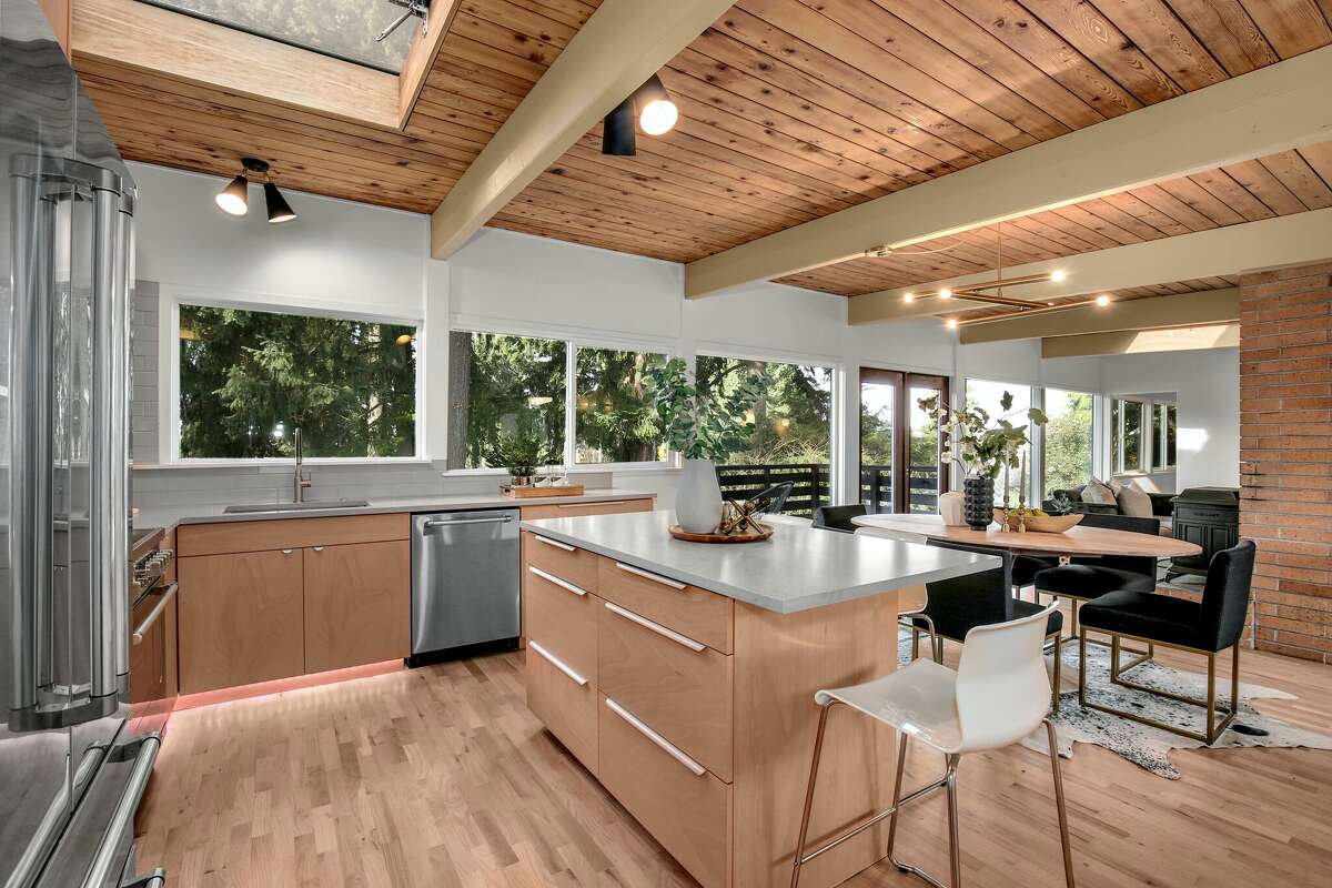 There is an open flow to the living, dining and kitchen areas, with overhead skylights and walls of windows letting in both natural light and the tree-line views. 