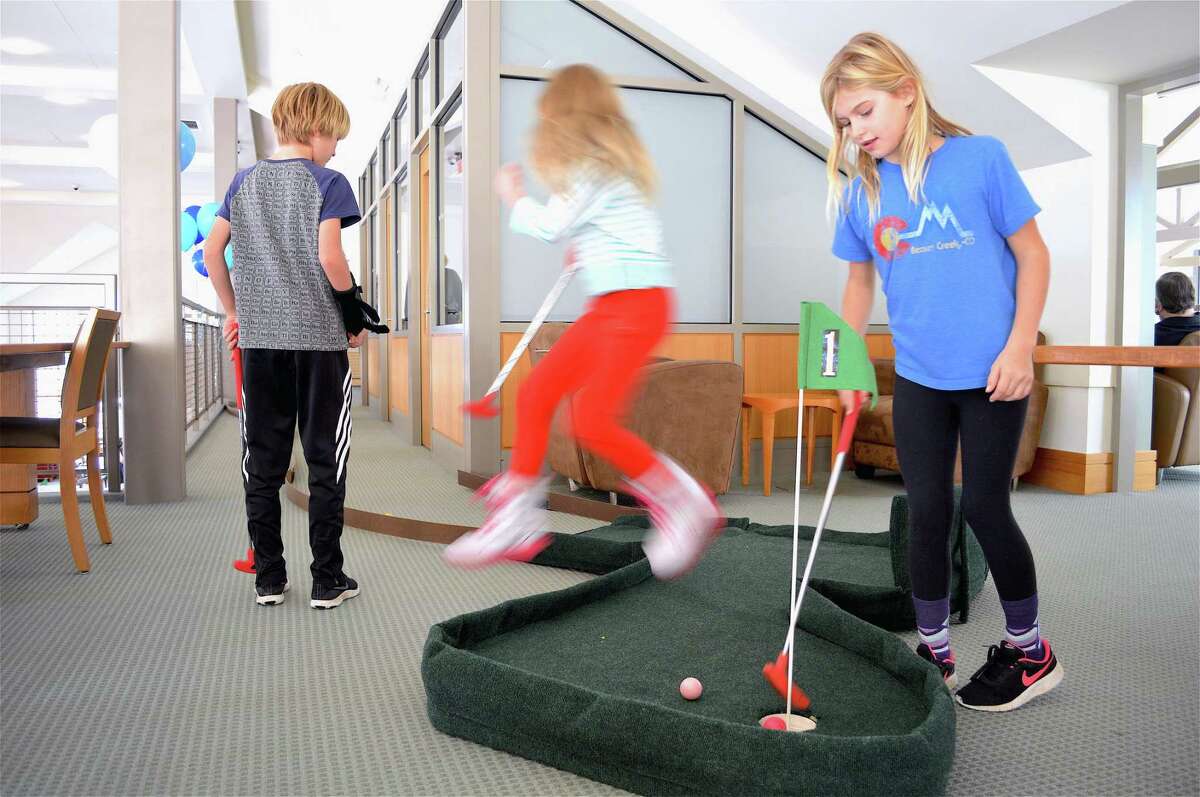 Kids hit the links on the mini golf course set up at the Darien Library on Saturday, Nov. 17, 2018.