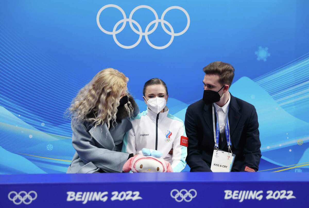 BEIJING, CHINA - FEBRUARY 15: Kamila Valieva of Team ROC waits for their score with choreographer Daniil Gleikhengauz (R) and coach Eteri Tutberidze (L)during the Women Single Skating Short Program on day eleven of the Beijing 2022 Winter Olympic Games at Capital Indoor Stadium on February 15, 2022 in Beijing, China. (Photo by Matthew Stockman/Getty Images)