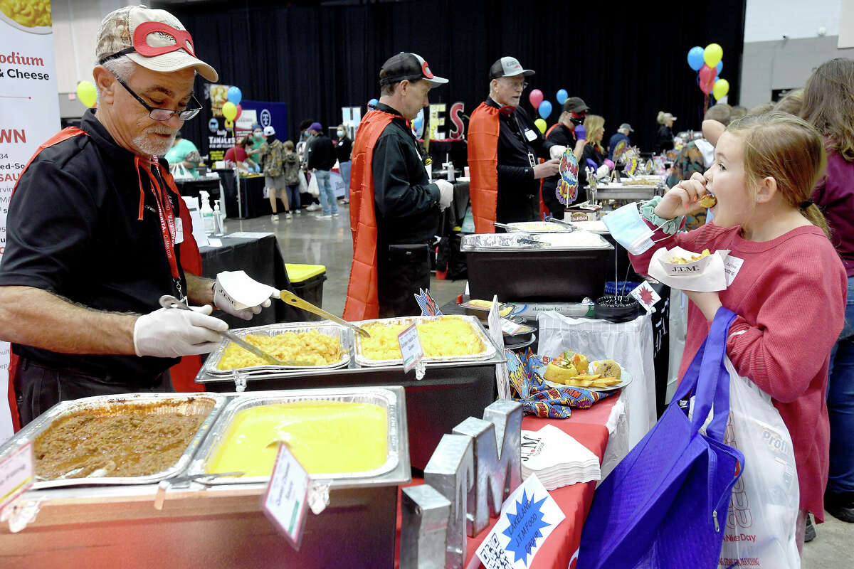 Davis Norris ladles out a sample of mac and cheese as Ava Tucker, a student member of the Spurger ISD's Principal Advisory Committee, samples items during the 22nd annual Region V Food Service Coop Show at the Civic Center. School lunch staff, nutritionists, parents and students got a chance to sample some of the latest and most popular vendor items tailored for school meal programs and nutritional goals. Participants voted on their favorites frrom among the tables filled with everything from beverages to snacks, meals and desserts. Photo made Tuesday, February 15, 2022 Kim Brent/The Enterprise