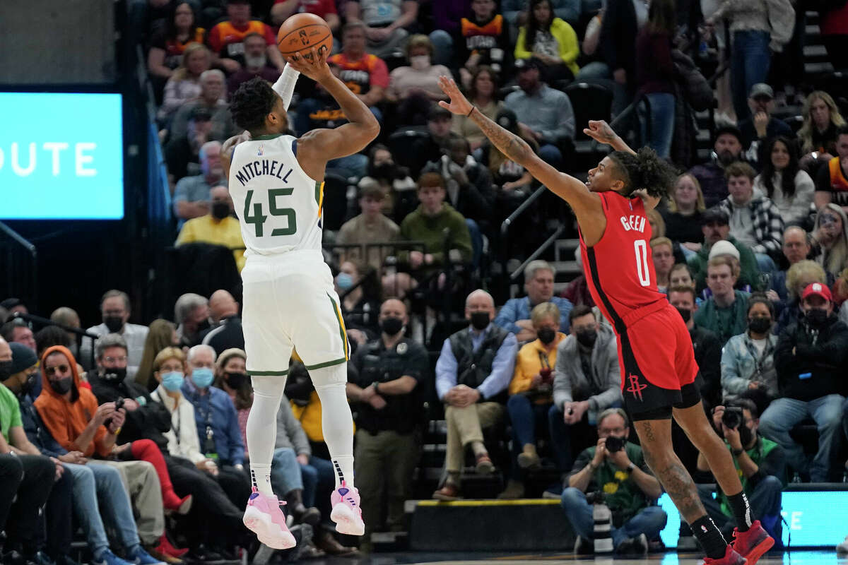 El jugador del Jazz de Utah Donovan Mitchell (45) lanza a canasta ante Jalen Green (0), de los Rockets de Houston, en la primera mitad del juego de la NBA que enfrentó a ambos equipos, el 14 de febrero de 2022, en Salt Lake City.