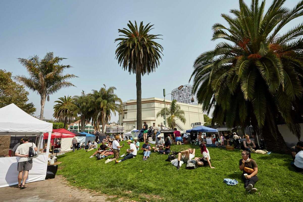 Shoppers relax at the Grand Lake Farmers Market in Oakland in August 2021. Homeowners in the surrounding neighborhood, which is predominantly white, save an average of $12,000 a year thanks to Prop. 13, compared to $3,000 a year in more diverse parts of East Oakland.