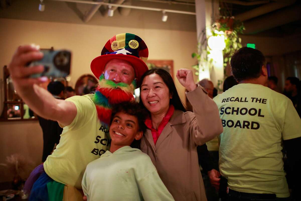 David Thompson (left) poses for a selfie with his son Lucas Tamayo-Thompson and friend Leanna Louie (right) as they celebrate at the pro-recall party at Manny’s restaurant on Tuesday, Feb. 15, 2022 in San Francisco, California.