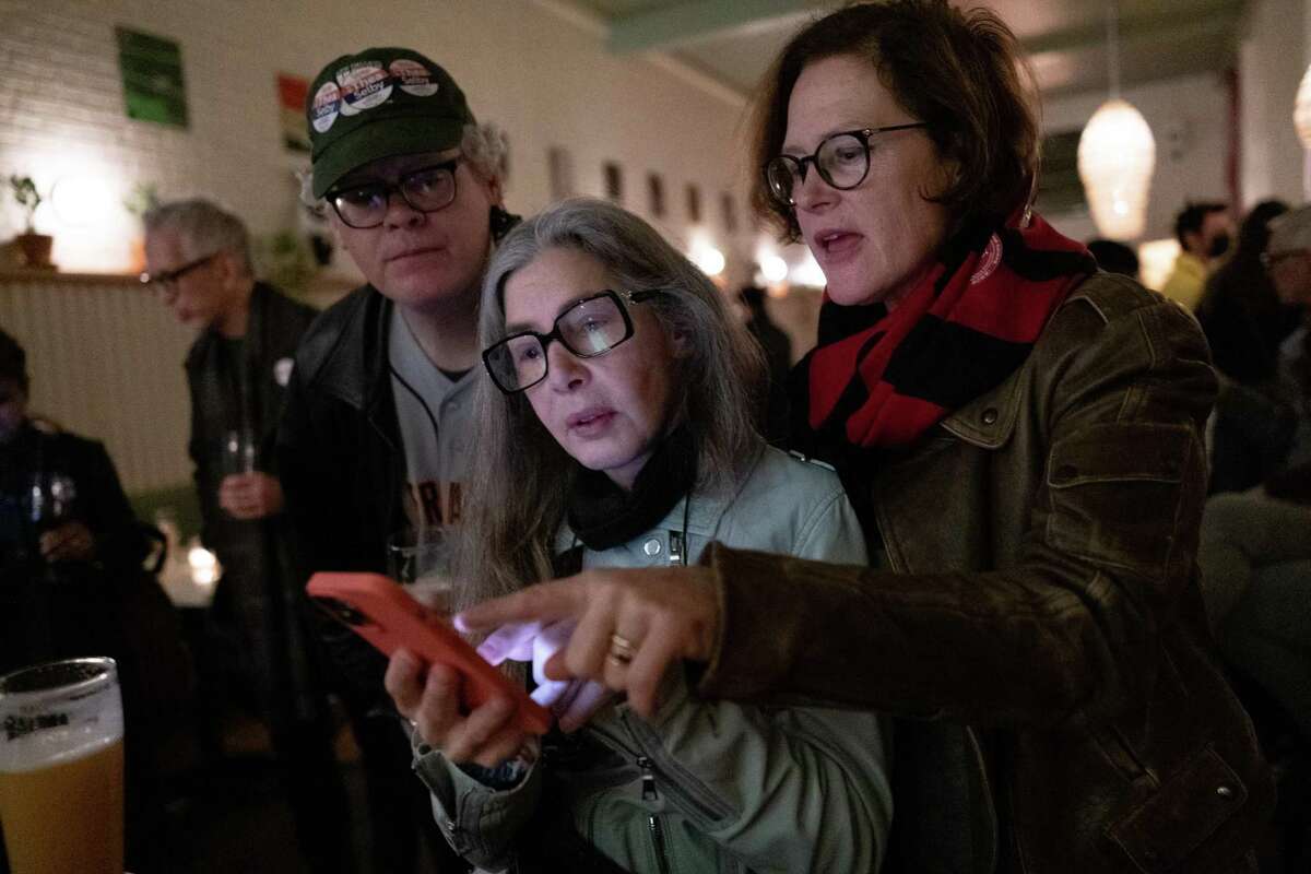 Assembly candidate Thea Selby, right, checks election results with Lynn Friedman and her brother, Gardner Selby, at her election night watch party on Tuesday February 15, 2022.