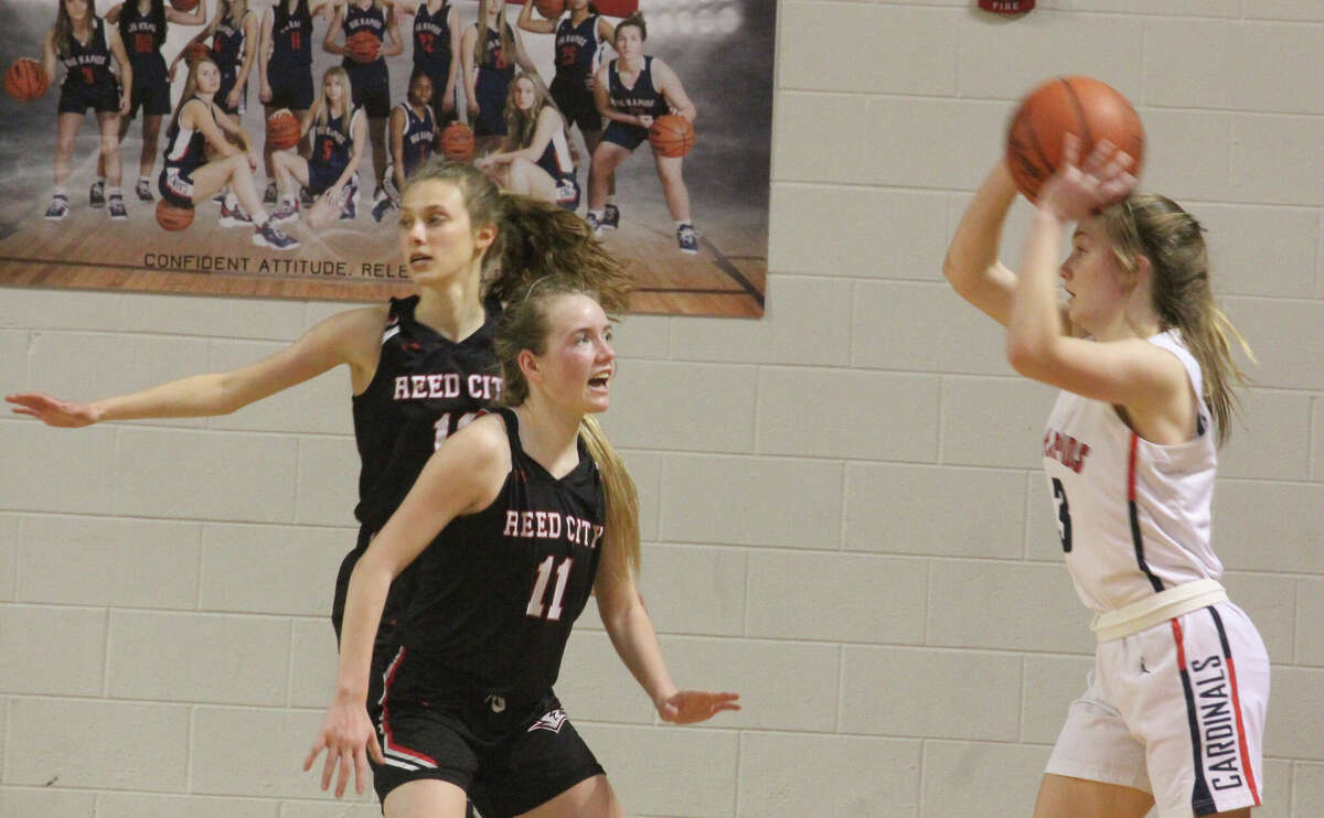 Reed City's Paige Lofquist defends against Big Rapids' Hanna Smith in Tuesday girls basketball action.