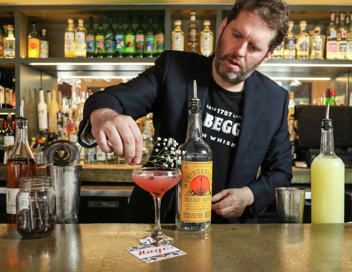 Sean Beck, sommelier and beverage director at Hugo’s, puts the garnish on a cocktail called Among the Wildflowers made with Chihuahuan desert sotol, hibiscus cordial, pineapple brandy and lime.