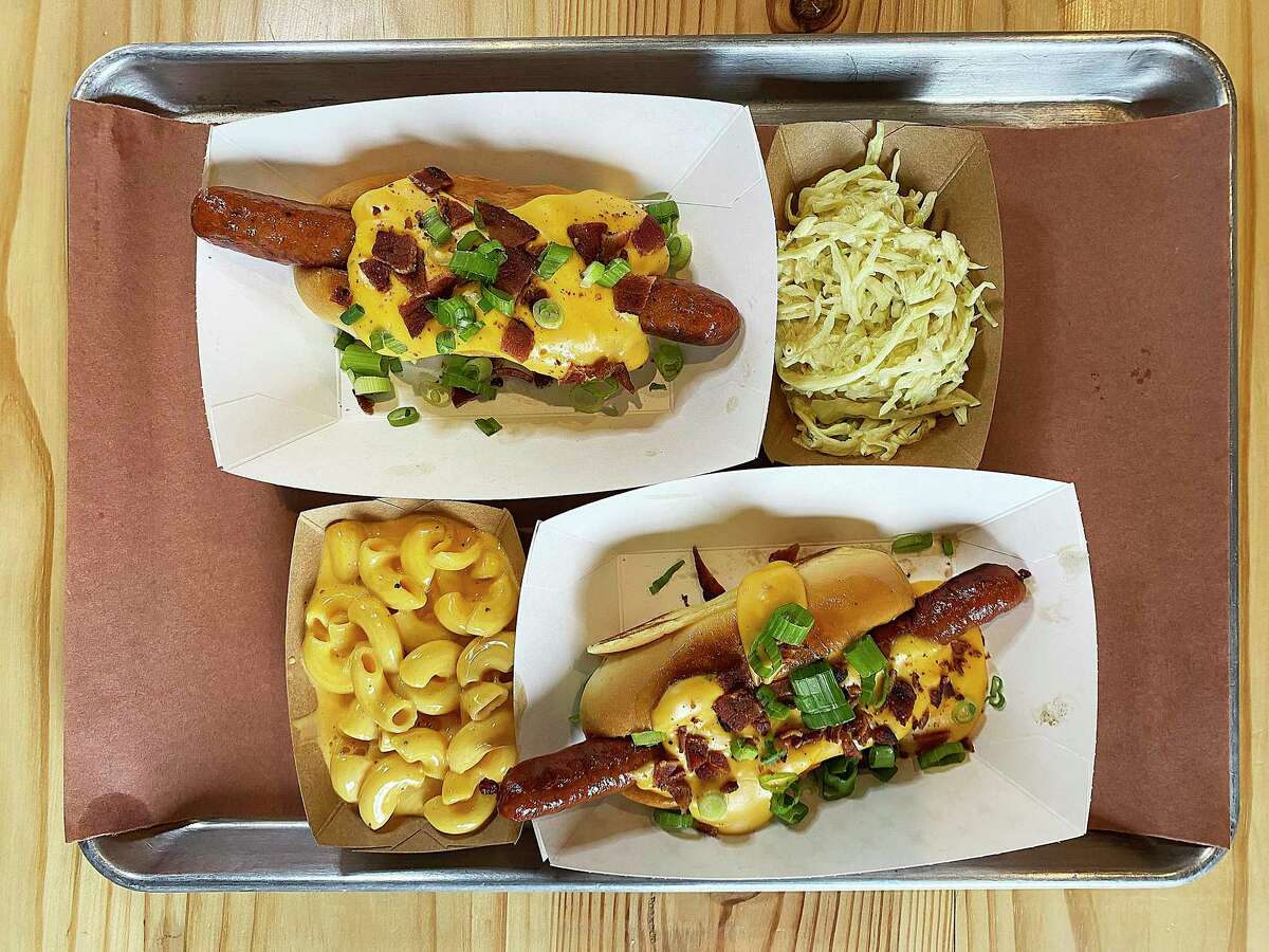 The Bandit Dog from Bandit BBQ at Freight Gallery on South Flores Street in San Antonio includes a housemade brisket hot dog, queso, bacon and chives on a Martin's potato roll, with optional sides like macaroni and cheese and coleslaw.