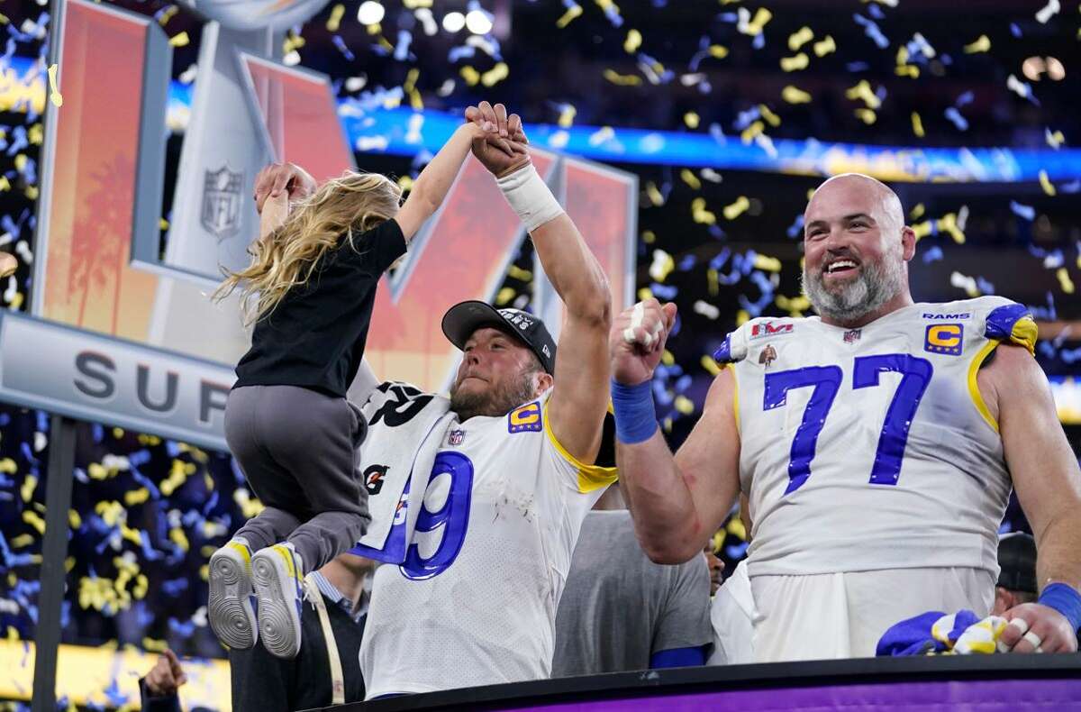 Los Angeles Rams quarterback Matthew Stafford (9) pulls up one of his daughters on stage while celebrating with offensive tackle Andrew Whitworth (77) after the Rams defeated the Cincinnati Bengals in the NFL Super Bowl 56 football game Sunday, Feb. 13, 2022, in Inglewood, Calif. More than $60 million was bet on the game at sportsbooks in Illinois.