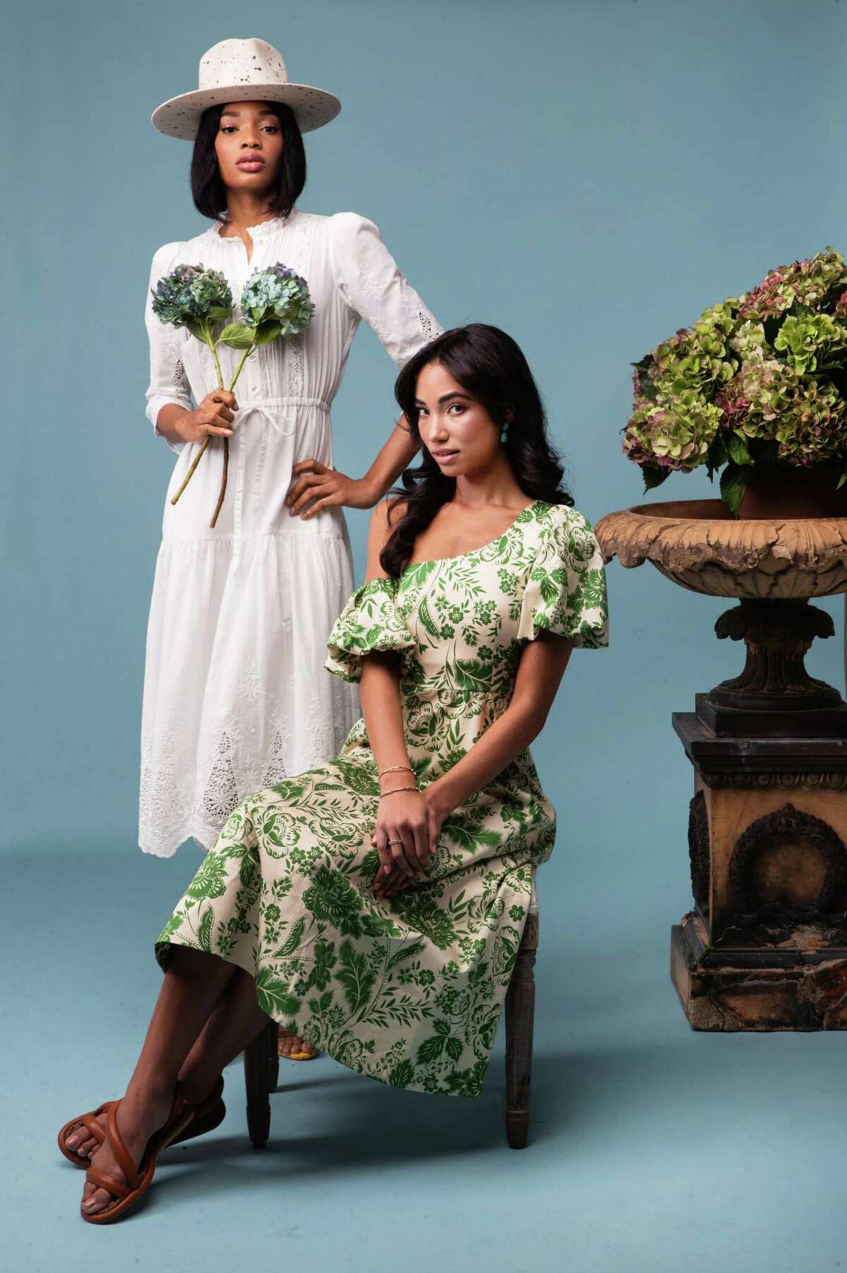 Glory, left, wears the Benedict dress, $425, by Hunter Bell; Bulan hat, $2,500, by Teressa Foglia; and Claudia heels, $495, by Aera. Gabriella wears the Magnolia dress, $475, by Hunter Bell; Gina sandals, $425, by Aera. Her Tina earrings, $1,850; Alyssa ring, $450; Marilyn ring, $600; Emily bangle, $1,450, and Nina bracelet, $500, are all by Christina Greene.