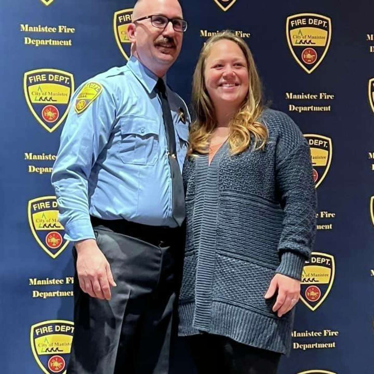 Chris Jeffries and Erica Jeffries stand side by side after performing the pinning ceremony marking him as a Manistee City Fire Department captain. 