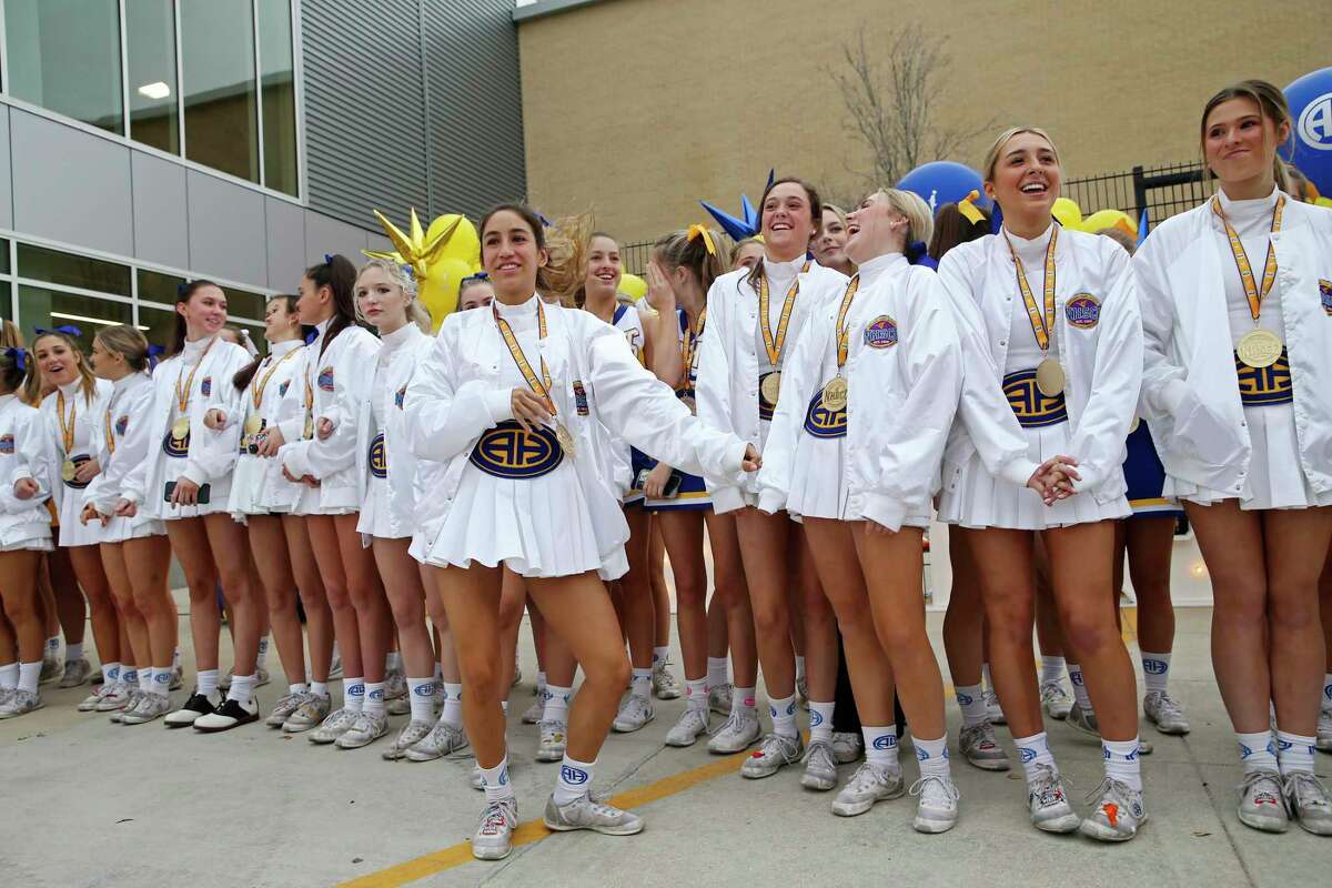 The Alamo Heights High School varsity cheerleaders are celebrated at the school Wednesday. They won gold medals in the UCA National Championship. The junior varsity cheerleaders won bronze in the event.