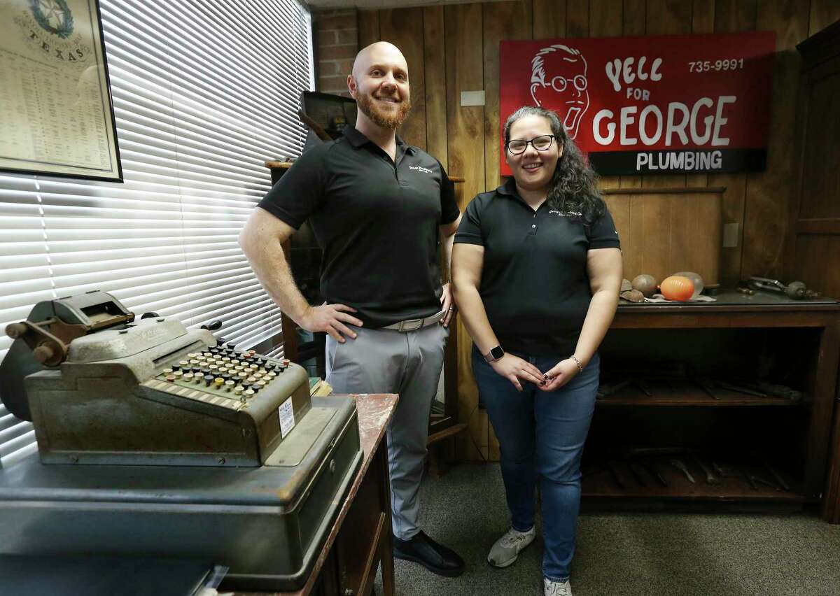 George Plumbing proprietor Clay Saliba (left) and Allie Perez, head of marketing and operations, pose for a photo in the company's "museum" on Wednesday, Feb. 2, 2022. Silba is a third-generation plumber who accepts Bitcoin for his company's services. The company has been accepting cryptocurrency since 2013.