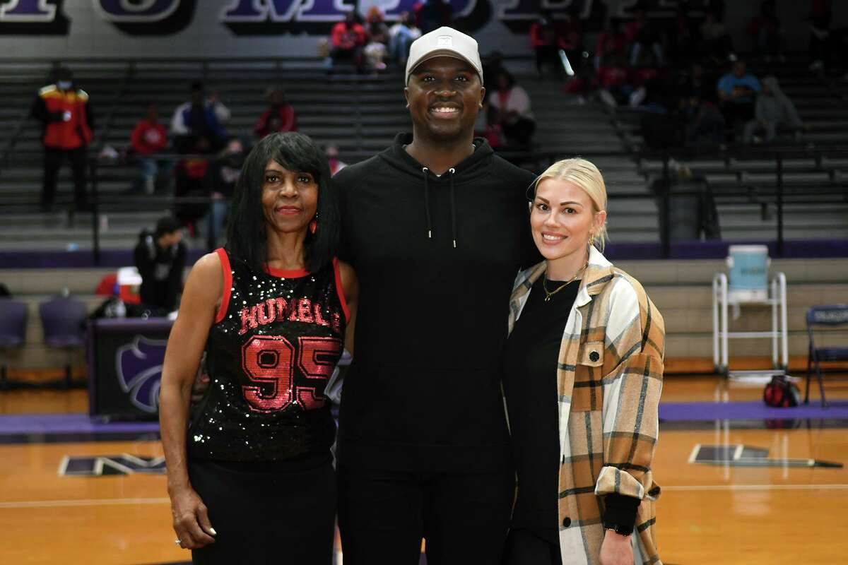 Humble High School alumnus Jerrod Johnson, center, poses for a photo with his mom Pam, left, and his wife Braidee during halftime of the Wildcats District 21-6A matchup with the North Shore Mustangs which was to be the final game ever in "The Pit" at Humble High School on Feb. 15, 2022.