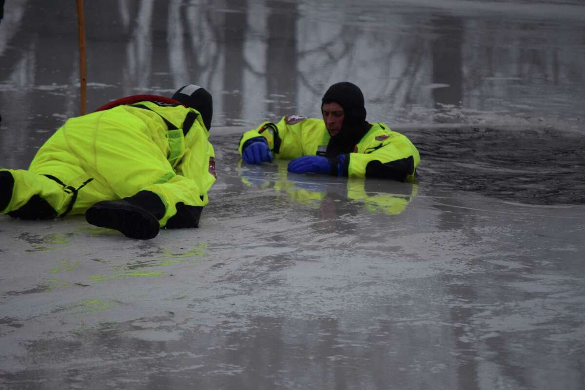 Jacksonville firefighter Brian Gillespie crawls to "rescue" fellow firefighter Chris Kesler as Jacksonville Fire Department members underwent ice rescue training Wednesday at Nichols Park Lake. The crew cut ice, pulled "victims" from the water, and practiced various rescue scenarios. More photos are available at myjournalcourier.com. Videos can be seen on the Journal-Courier's YouTube channel.