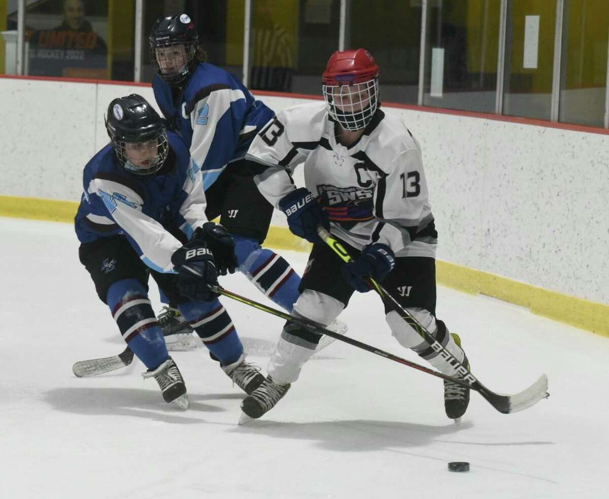 SWS' Meadow Gilchrist (13) is defended by ETB' Mallory Pierz (24) during a girls hockey game on Feb. 2, 2022.
