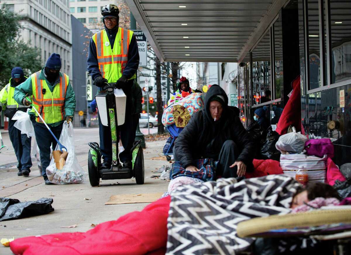 A member of the Downtown District - who declined to give his name - rides down the sidewalk of Fannin Street after waking up the homeless people sleeping there on Thursday, Feb. 3, 2022, in Houston.