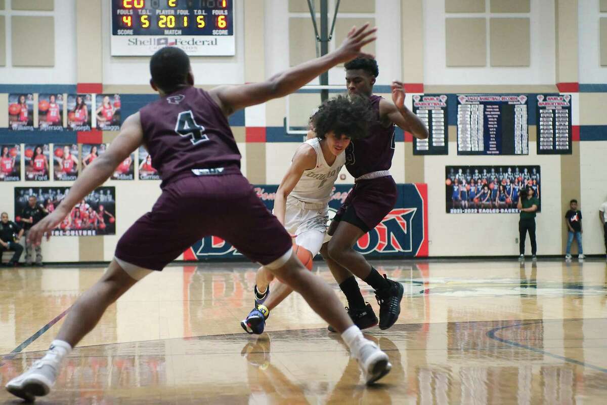 Dawson’s Jaden Miller (1) drives to the basket past Pearland’s Charles Clark (4) and Pearland’s Patrick Bridges (23) Wednesday, Feb. 16, 2022 at Dawson High School.