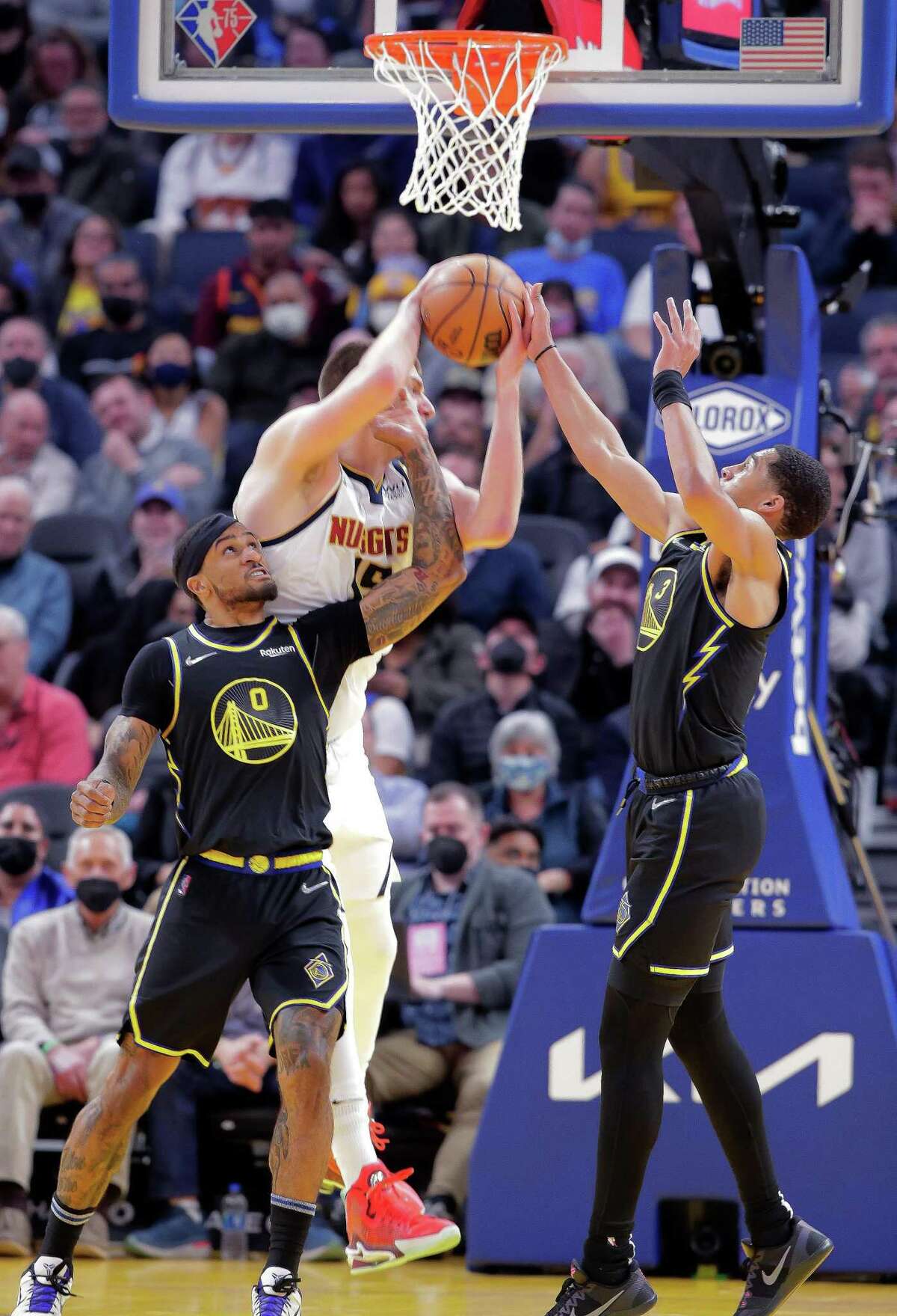 Gary Payton II (0) and Jordan Poole (3) defend against Nikola Jokic (15) in the first half as the Golden State Warriors played the Denver Nuggets at Chase Center in San Francisco, Calif., on Wednesday, February 16, 2022.