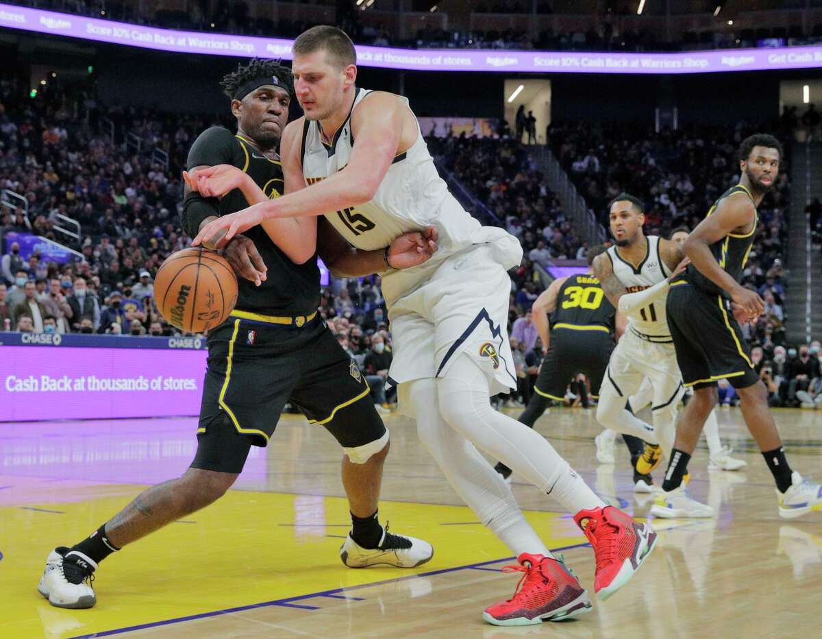 Kevon Looney (5) defends against NIkola Jokic (15) in the second half as the Golden State Warriors played the Denver Nuggets at Chase Center in San Francisco, Calif., on Wednesday, February 16, 2022. The Warriors were defeated 117-116 on a last second three pointer by Monte Morris (11)