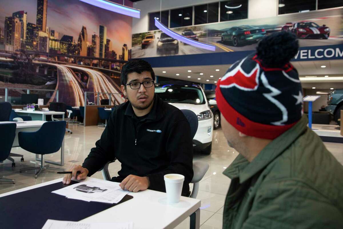 Car sales specialist Javier Medina Jr. helps Pedro Gonzalez building a Super Duty F-350 Thursday, Jan. 20, 2022, at Doggett Ford in Houston. Gonzalez wanted to get a truck for his construction company as soon as possible, but Medina said the orders are backed for at least six months.