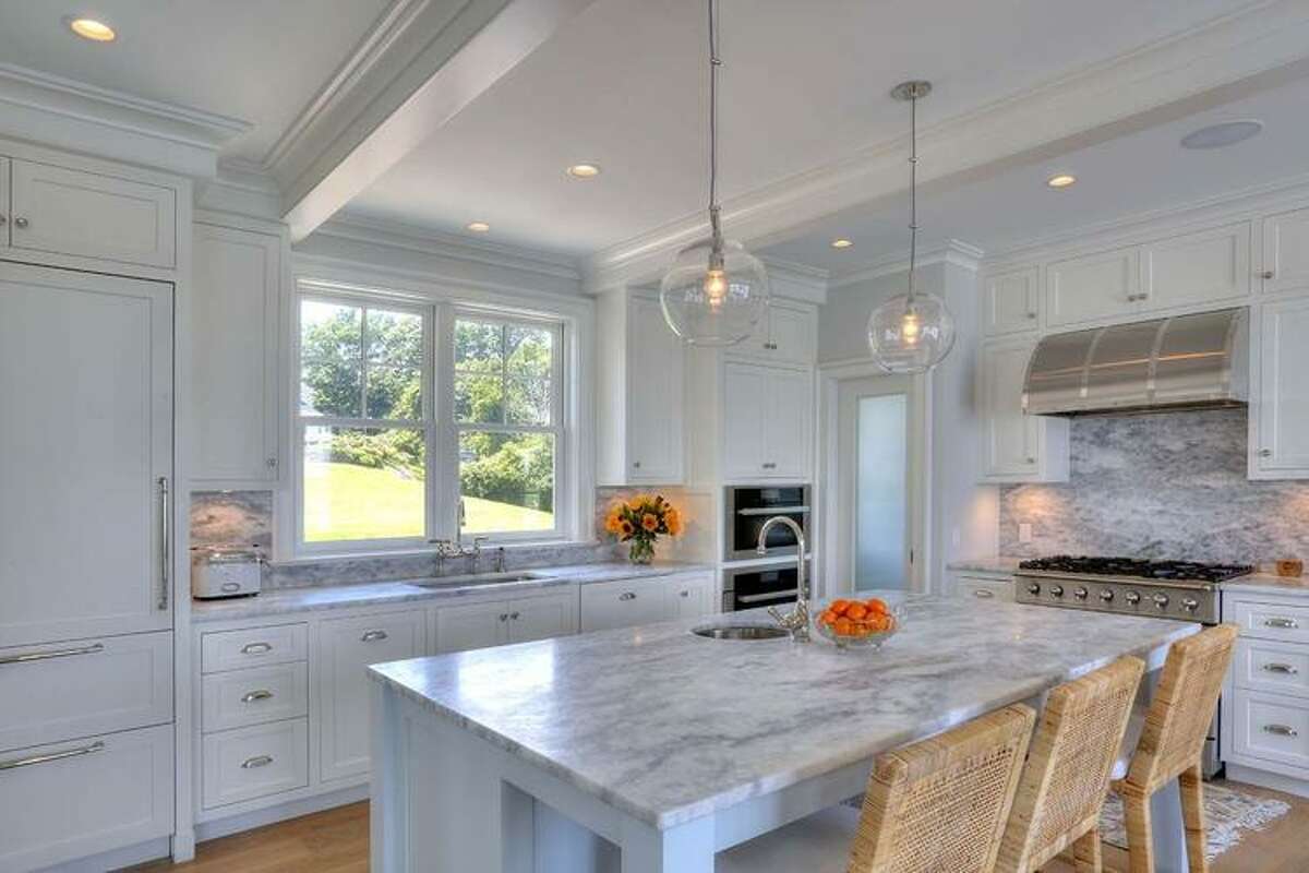 Besides plentiful outside views, the first-floor living and dining rooms and kitchen are open, and feature soft colors and patterns that reflect coastal New England and let those beachy vistas stand out.