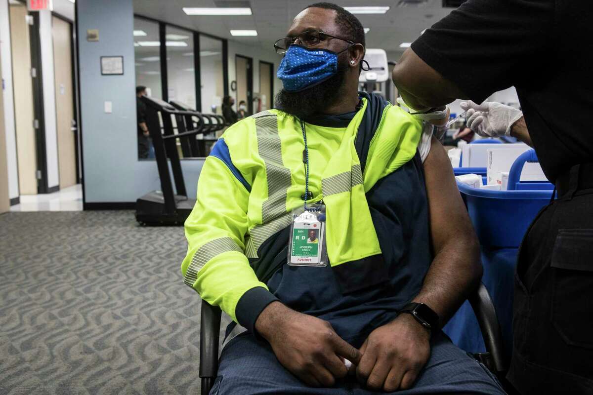 United Airlines employee Eric Joseph receives a Pfizer-BioNTech COVID-19 vaccine from Gladys McGinnis during a vaccine clinic at George Bush Intercontinental Airport Tuesday, April 27, 2021 in Houston. United Airlines has been vaccinating their IAH-based employees at the on-site airport employee clinic. United has now extended the invitation to vaccinate all airport workers and the airline's business partners.