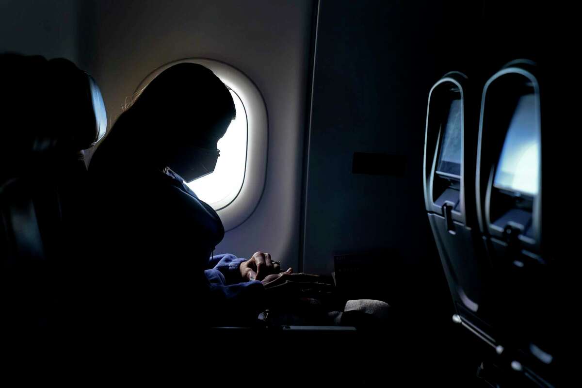 A passenger wears a face mask as she travels on a flight. The CDC says everyone, vaccinated or unvaccinated, should continue to wear a mask in certain places. Masks are still required on public transportation and in other settings like hospitals, prisons and homeless shelters. (AP Photo/Charlie Riedel, File)