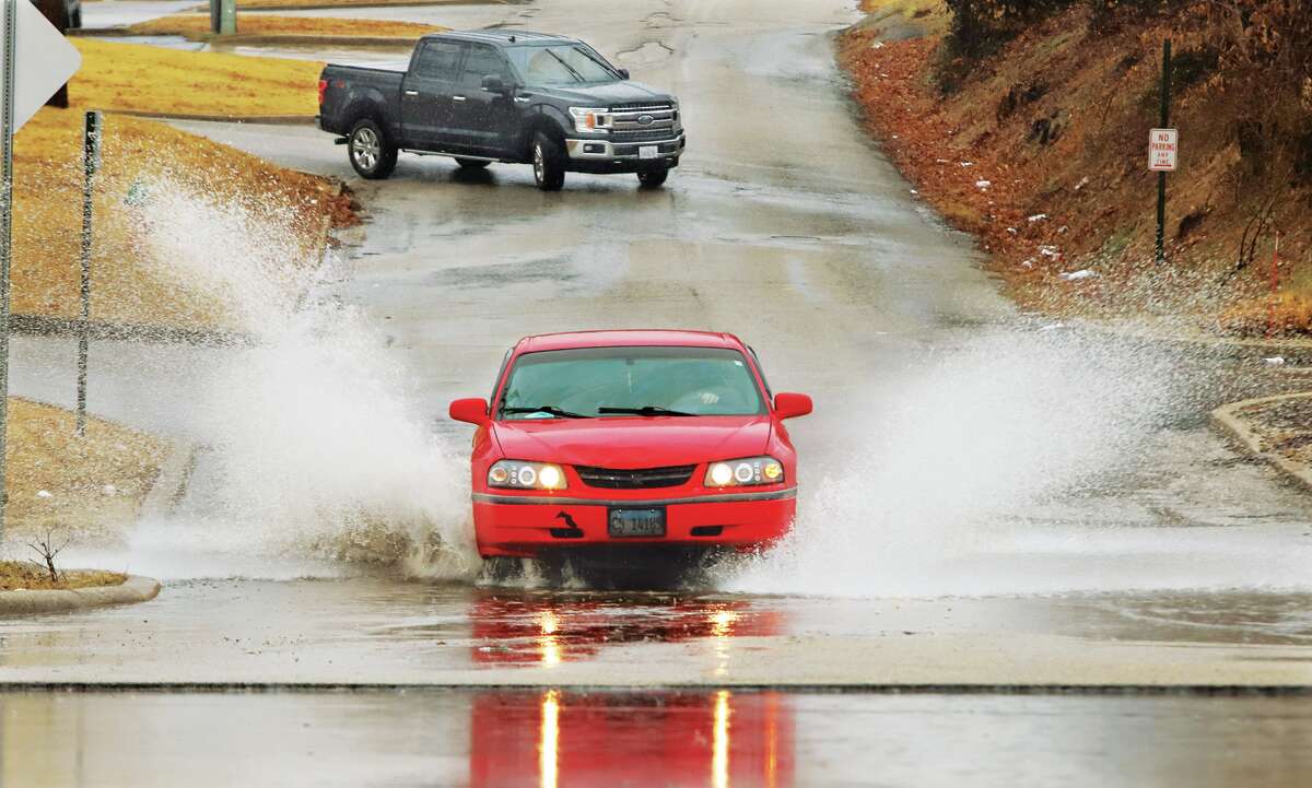 John Badman|The Telegraph A motorist splashes through standing rain on Humbert Street in Alton Thursday about an hour before the precipitation swithched over to sleet.