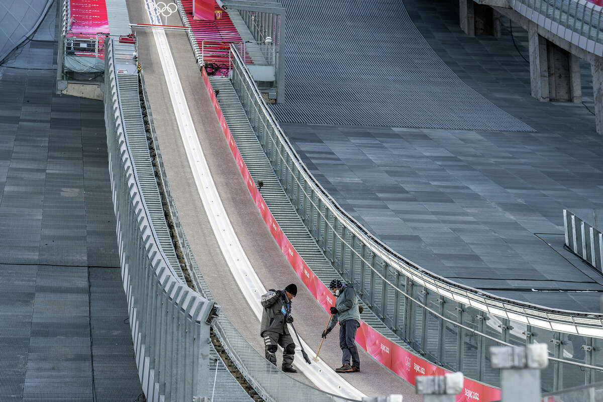 Staff sweep and check the slope before competition at the National Ski Jumping Center on February 7 in Zhangjiakou, China. Competitions held during the Beijing 2022 Winter Olympics will be held entirely on artificial snow created by a number of processes, including the flooding of dry riverbeds and the diversion of water supplies.