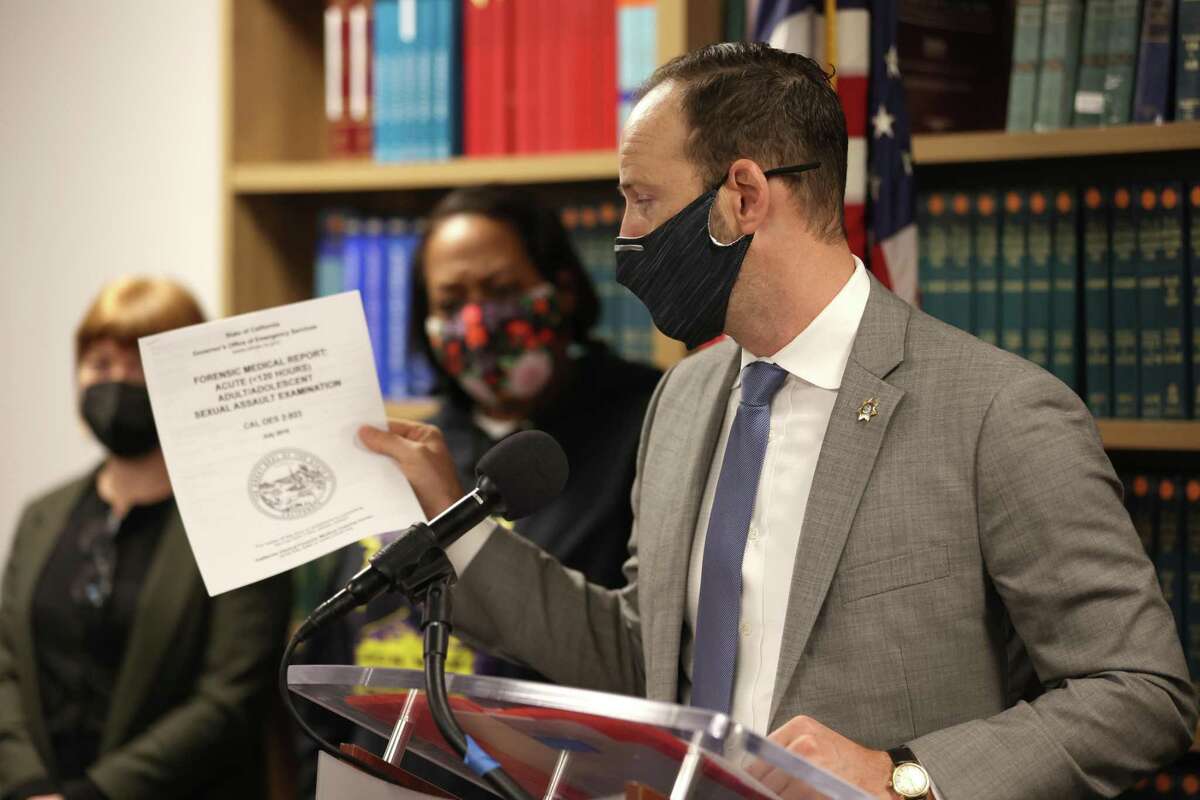 San Francisco District Attorney Chesa Boudin holds a copy of the California State medical examination form for sexual assault victims during a press conference Tuesday about the city Police Department’s practice of logging DNA evidence from rape kits into their crime database to use as evidence in other crimes.